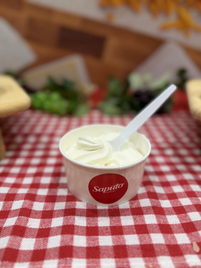 Soft serve in a custom Saputo branded cup on a red checkered tablecloth