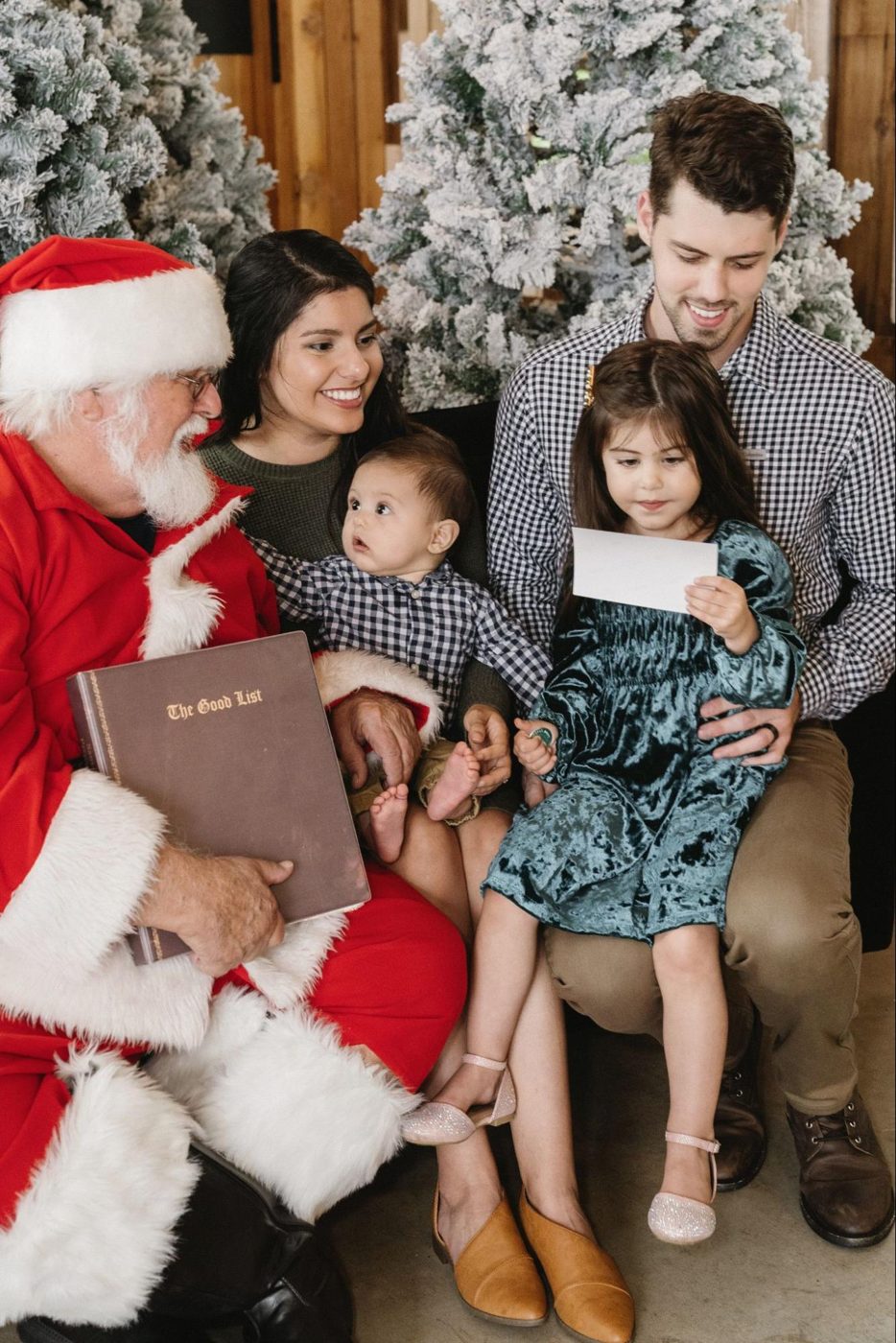 Kids and parents smiling with Santa for family Christmas photos