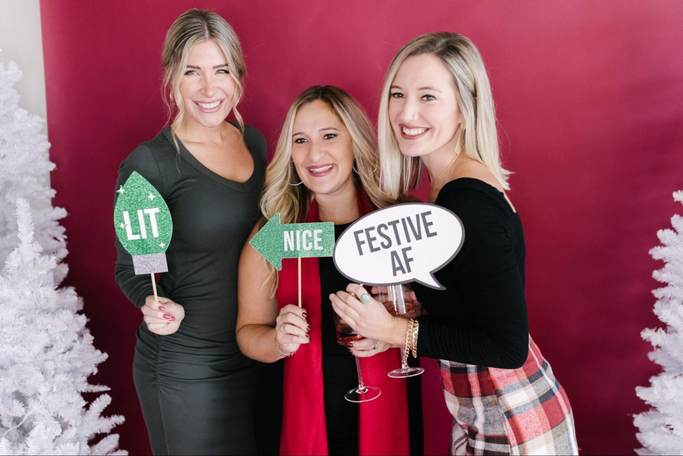 Guests posing with holiday photo booth props at a Christmas party